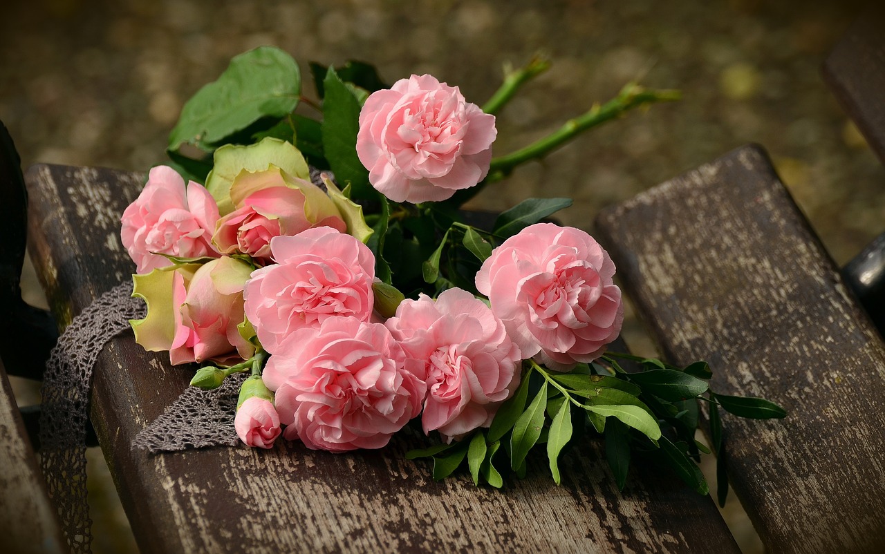 Des roses de couleur rose posées sur une table en bois
